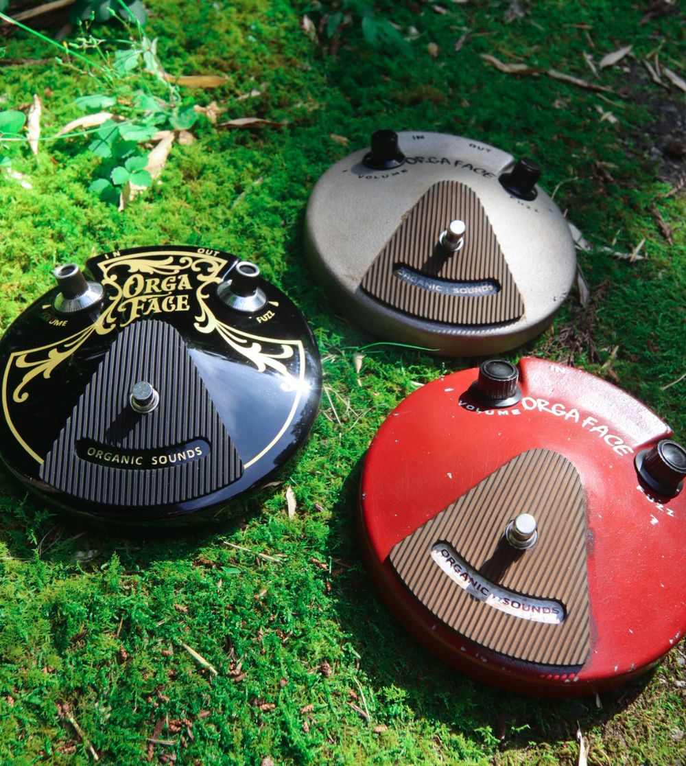 Three ORGA FACE fuzz pedals photographed on green moss